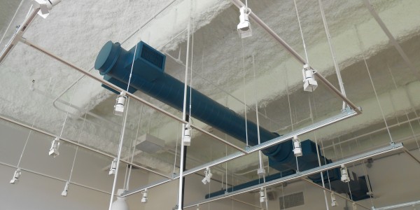 An exposed ceiling coated with acoustic spray to help reduce office noise.