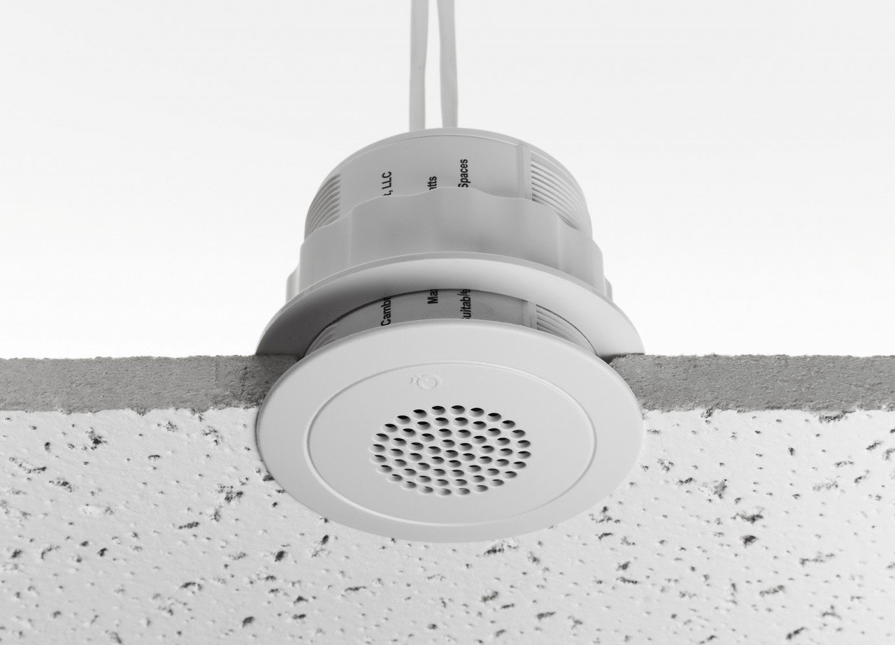 A sound masking speaker mounted in a typical office ceiling tile.